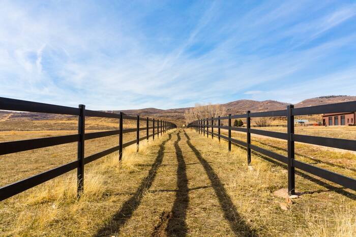Steel board fence extending across open rangeland